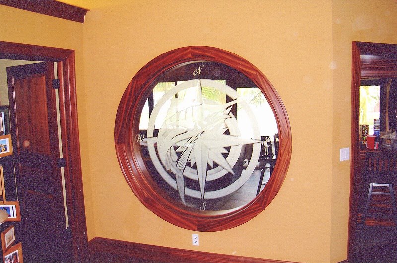 Compass-rose etched mirror in a hand-shaped mahogany frame