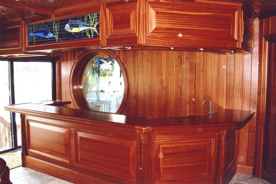 Curved mahogany bar with round etched mirror and beadboard back