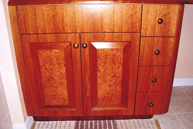 Cherry vanity with burl-panel doors and a marble top