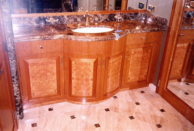 Curved vanity in cherry and burl with marble counter