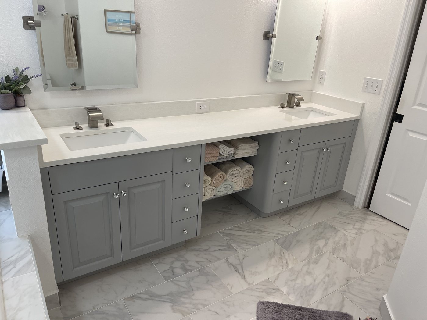 Grey double vanity with a quartz top, undermount sinks and open towel shelf