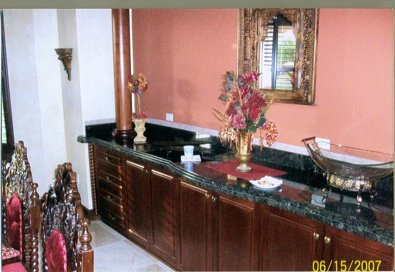 Cherry dining buffet with green granite and a framed mirror
