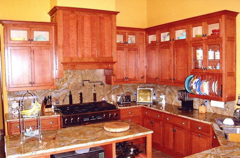 Cherry kitchen with raised-panel cabinetry and a burl-topped serving bar