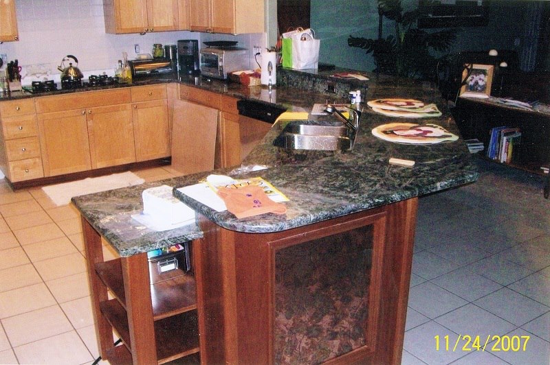 Curved granite island with cherry base and open shelving