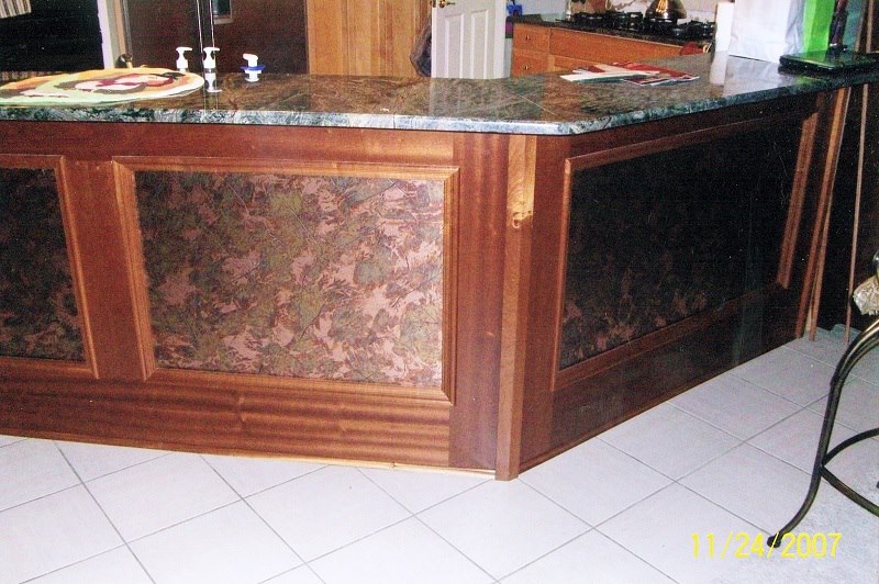 Furniture-style island with framed marble panels and green granite