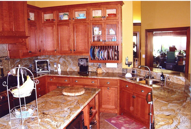 L-shaped cherry kitchen with granite tops and glass-front uppers