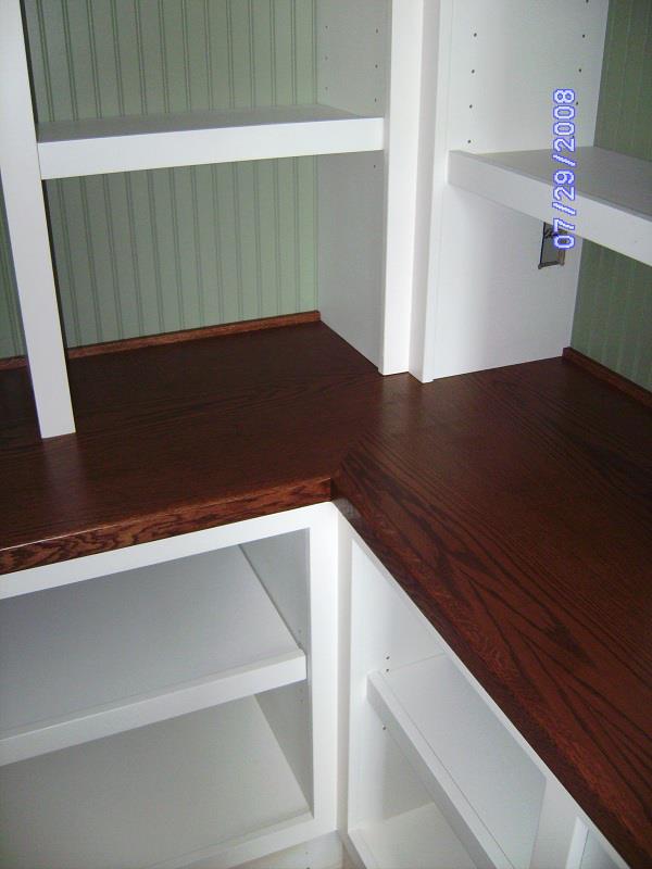 Corner built-in shelving with a stained hardwood ledge