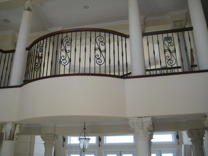 Curved balcony balustrade with iron scrollwork and columns
