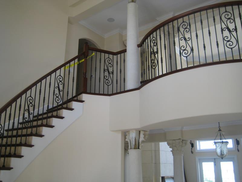 Two-story stair hall with iron balustrade and columns