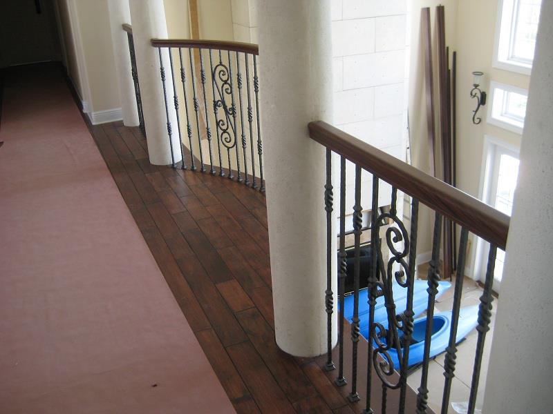 Upper gallery with hardwood floor and iron railing