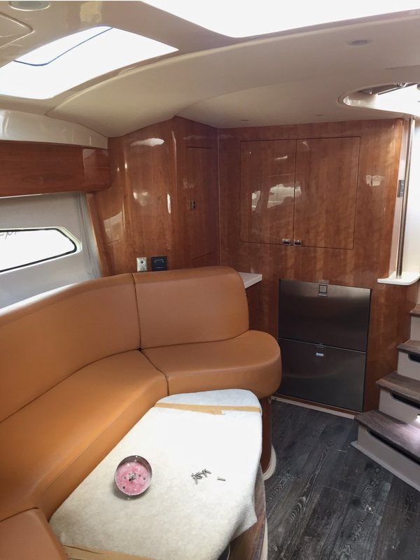 Cherry saloon cabinetry with a leather settee and stainless fridge drawers