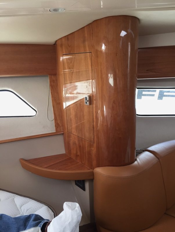 Curved high-gloss cherry bulkhead with a locker door and corner shelf