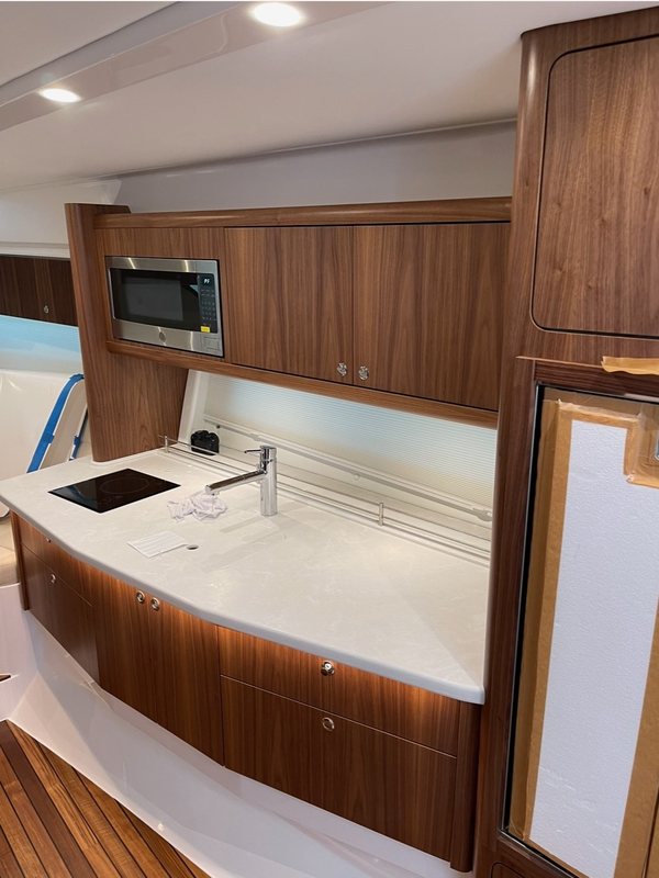 Walnut galley run with a quartz counter, sink and induction cooktop