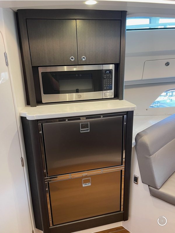 Walnut galley tower with a microwave and stainless refrigerator drawers