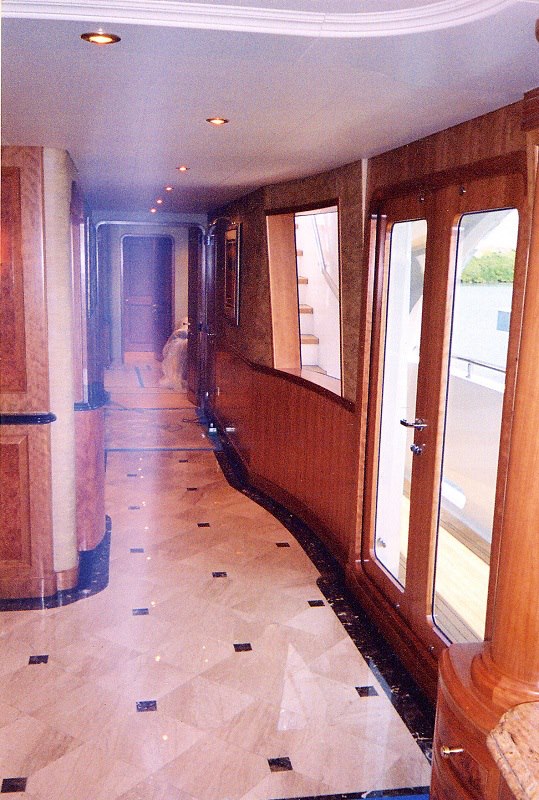 Yacht corridor with book-matched paneling and stone floor