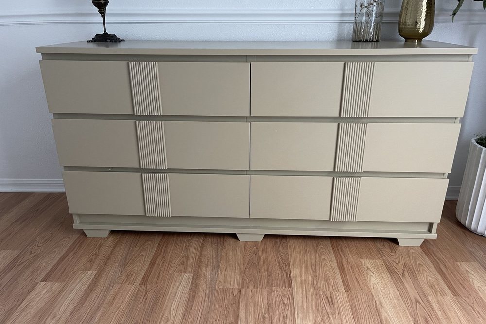 A painted dresser with reeded drawer-front panels and tapered feet